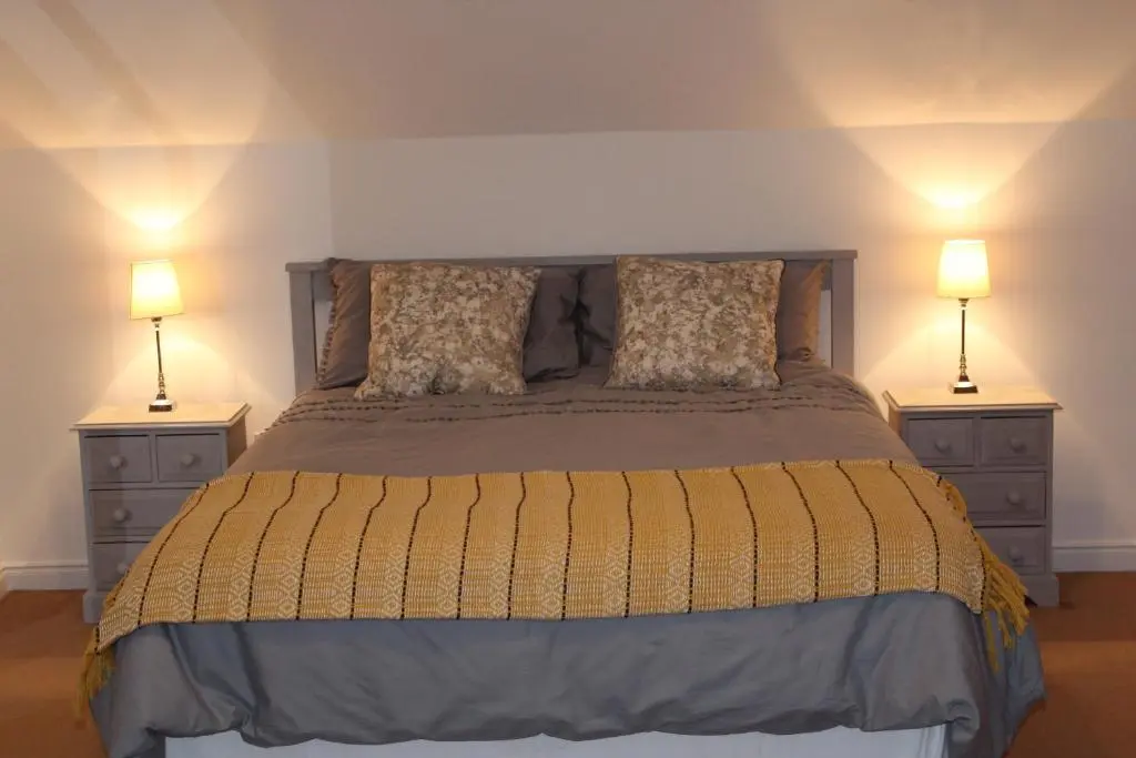 a bedroom with a bed with two night stands at Roualeyn in Huntly