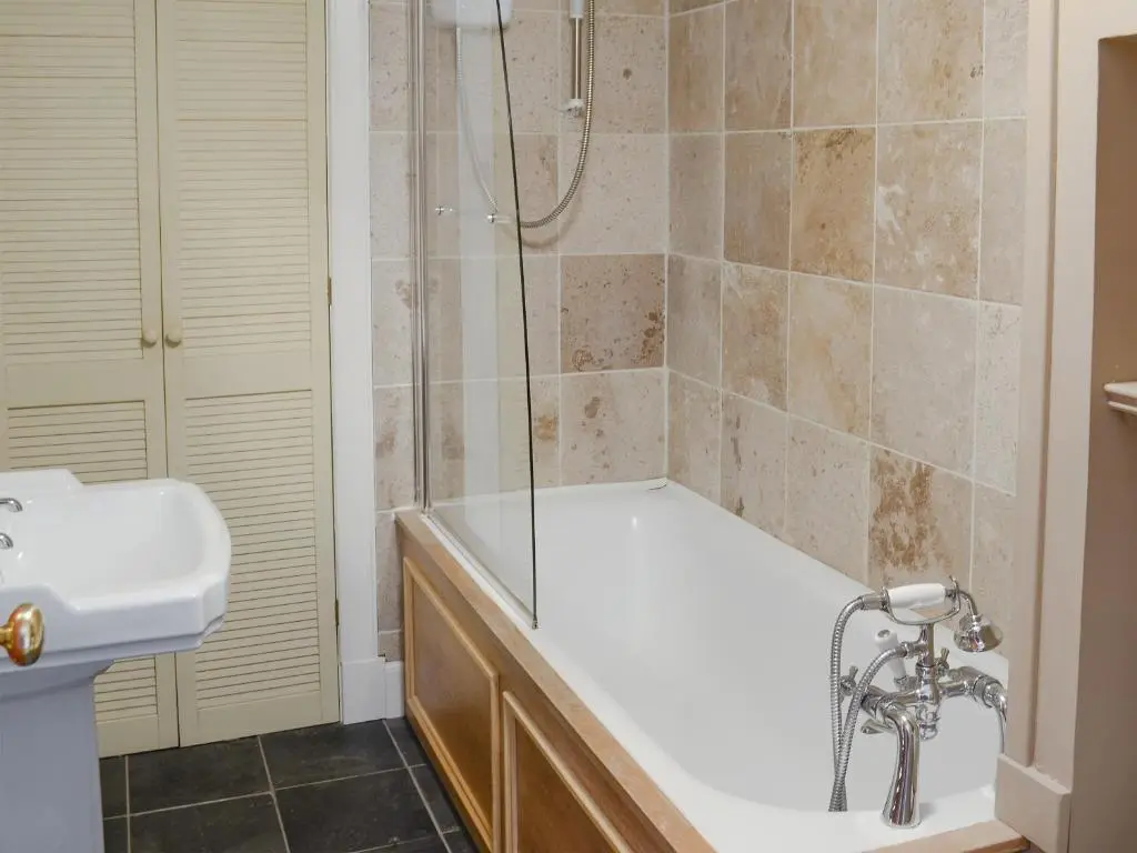 a bathroom with a tub and a sink and a shower at Tressady Coach House in West Langwell