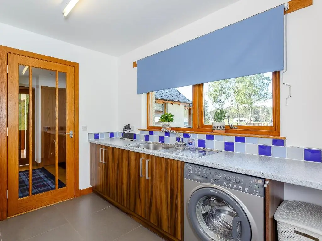 a laundry room with a washer and dryer at Sunnyside House in Duthil