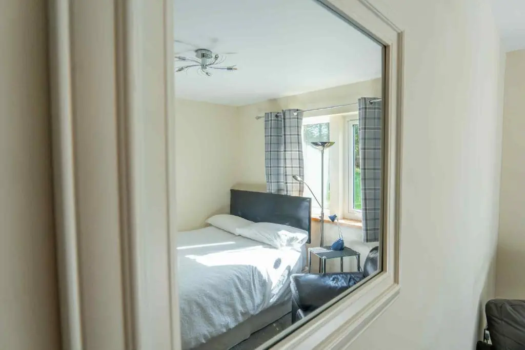 a mirror reflection of a bed in a bedroom at Drumlochy B&B in Inverness