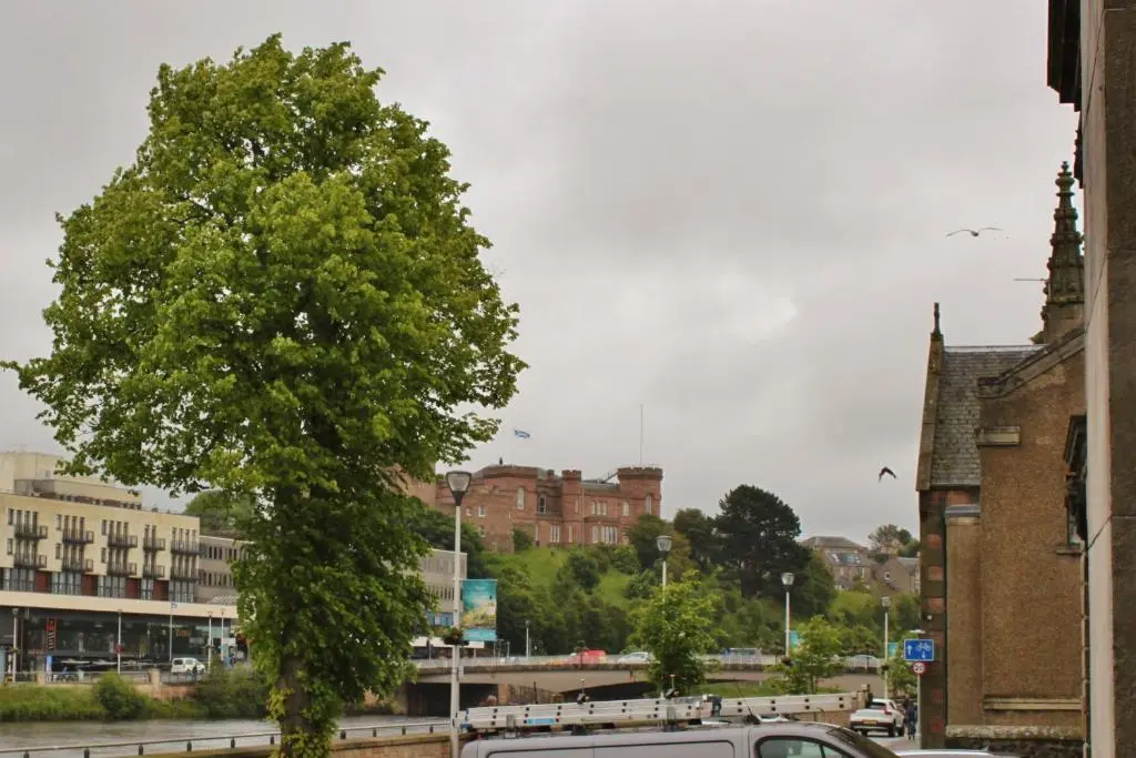 a van parked next to a tree in a city at The Bell Tower in Inverness