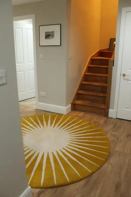 a hallway with a yellow and white rug on the floor at The Bell Tower in Inverness
