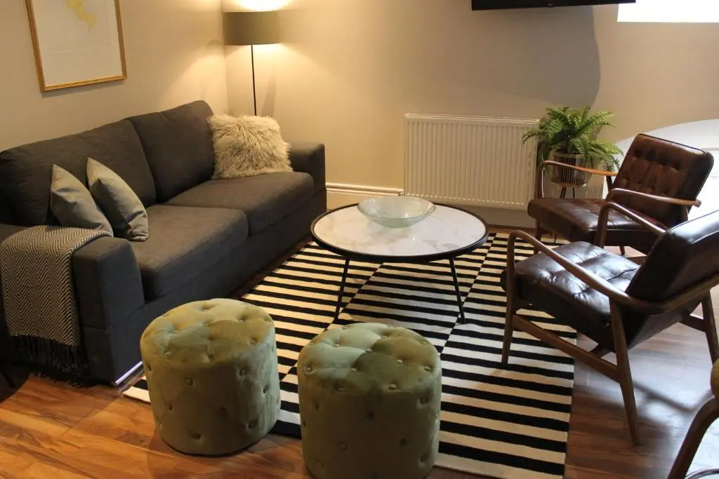 a living room with a couch and two chairs and a table at The Bell Tower in Inverness