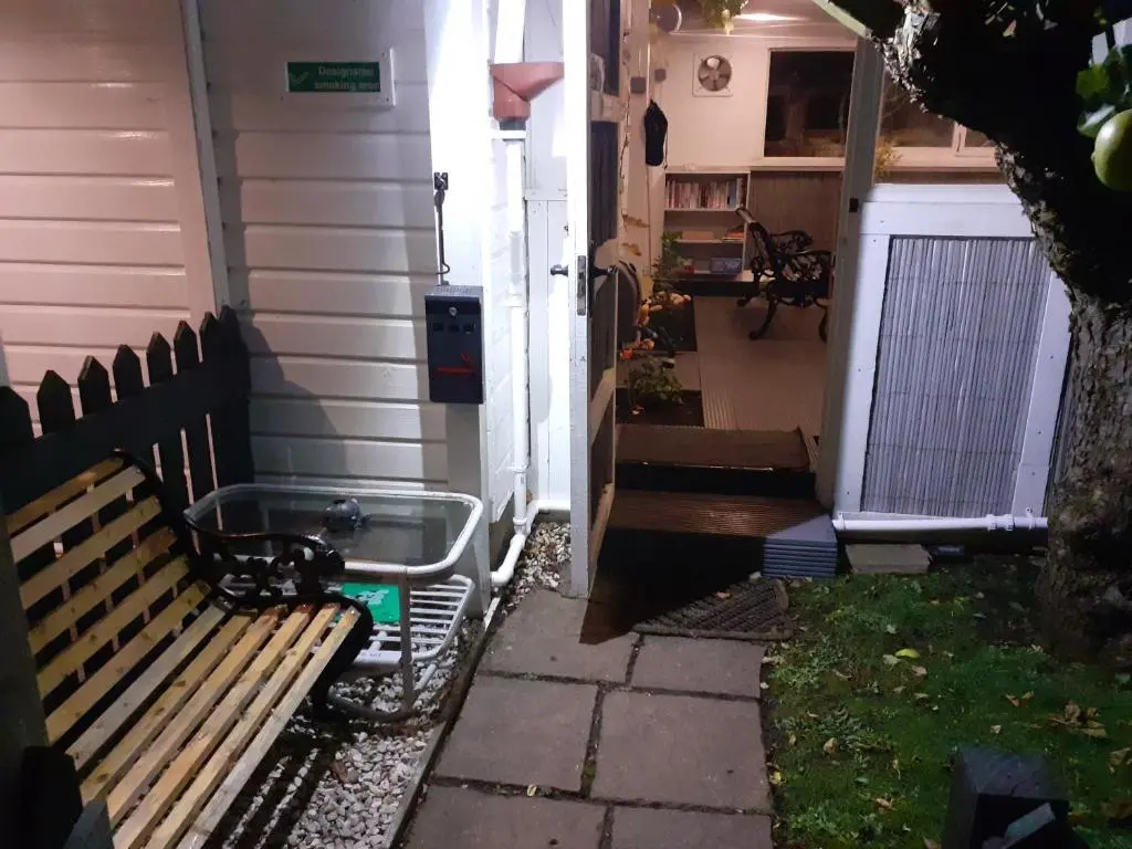 a bench sitting outside of a house next to a door at The Treehouse by Airlie in Nairn