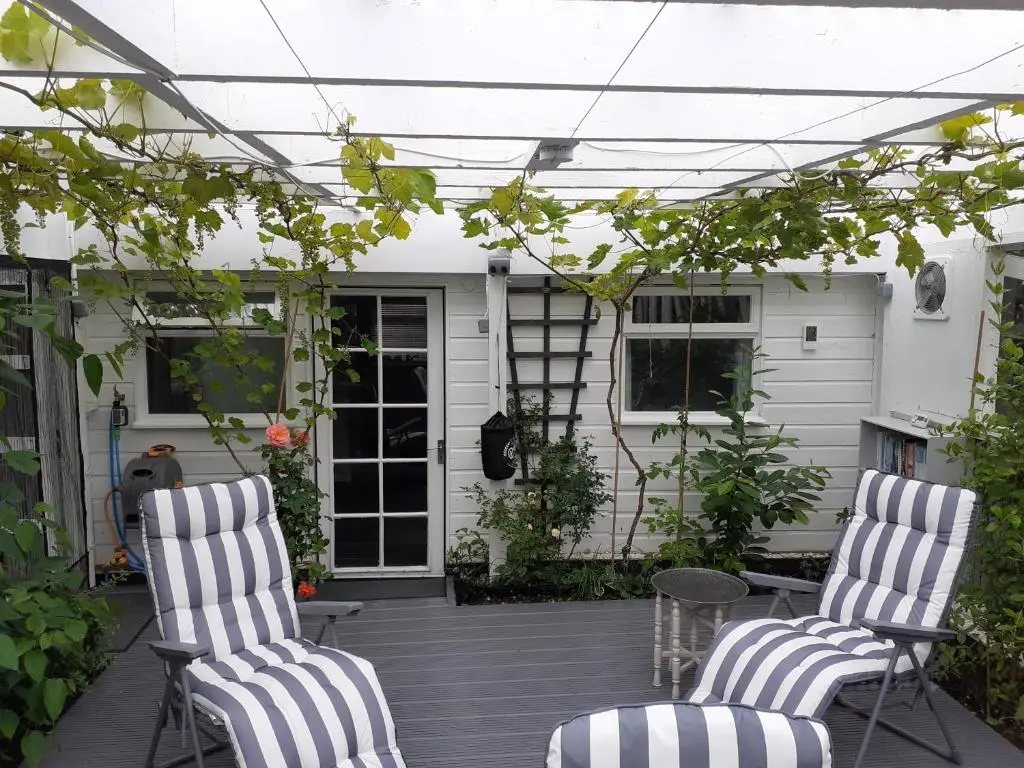 two chairs on a porch with a pergola at The Treehouse by Airlie in Nairn