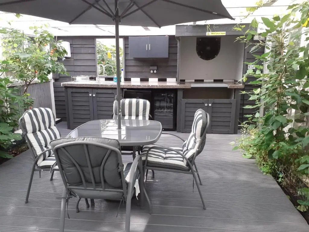 a table and chairs with an umbrella on a patio at The Treehouse by Airlie in Nairn