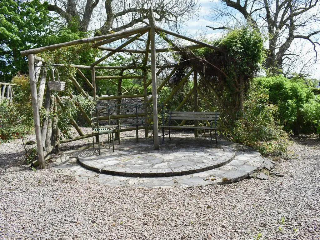 a park bench sitting on a circle in a garden at Middle Lodge in Mintlaw