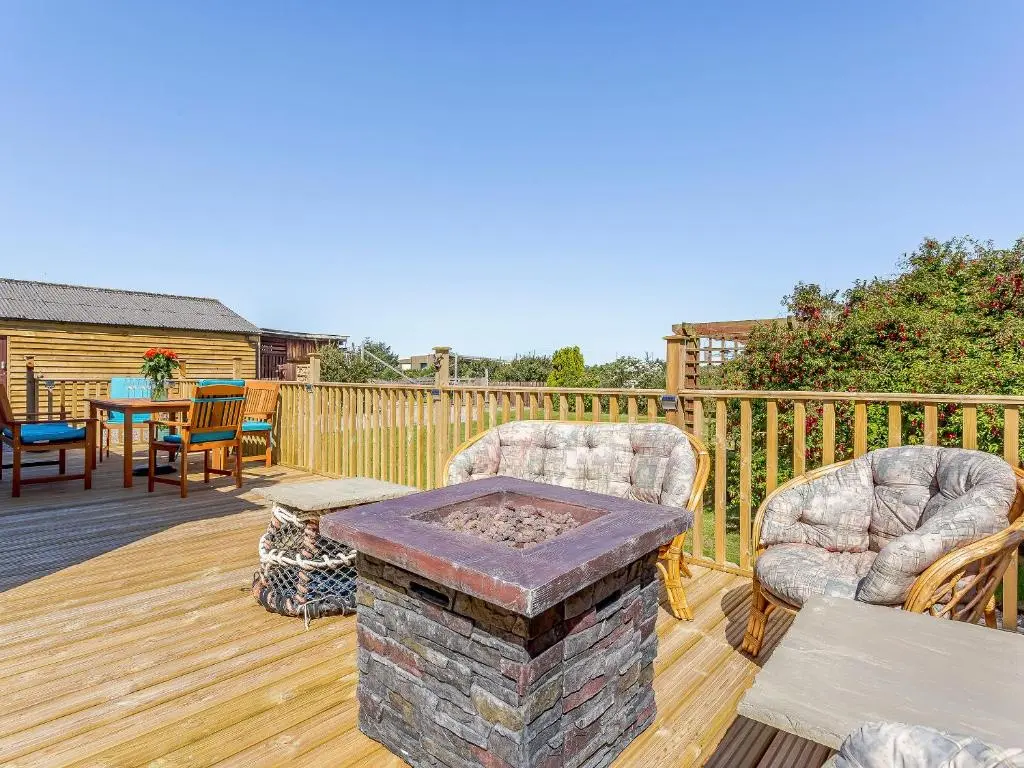 a patio with two chairs and a table on a deck at Inverspey in Kingston