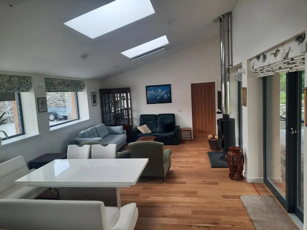 a living room with a white table and chairs at Carnmore Cottage in Inverness