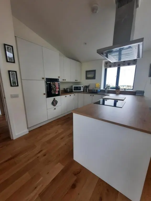 a kitchen with white cabinets and a white counter top at Carnmore Cottage in Inverness