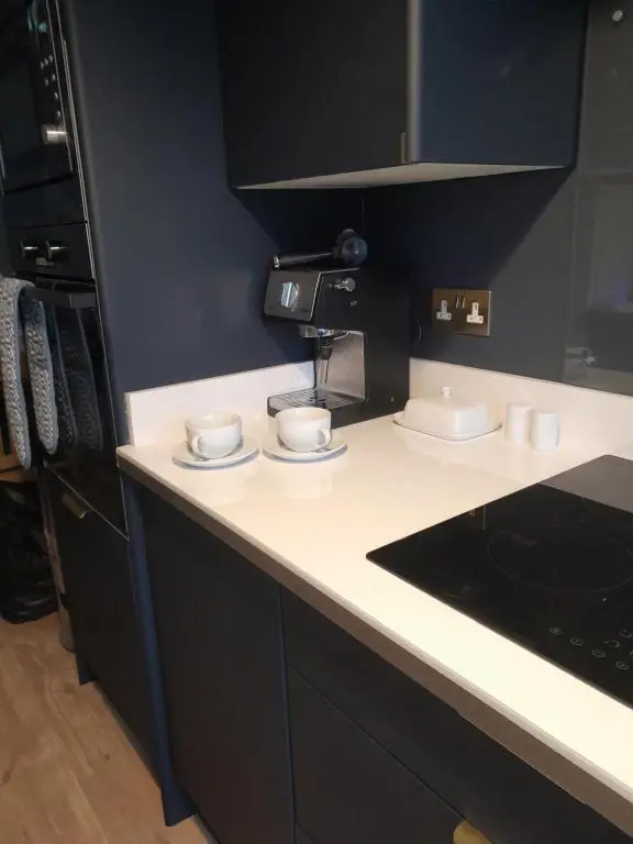 a kitchen with two coffee cups on a counter at WELCOMEHOUSE close to east beach, shops, restaurants and RAF base in Lossiemouth