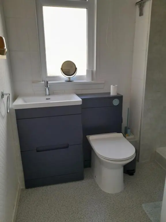a bathroom with a toilet and a sink and a window at WELCOMEHOUSE close to east beach, shops, restaurants and RAF base in Lossiemouth