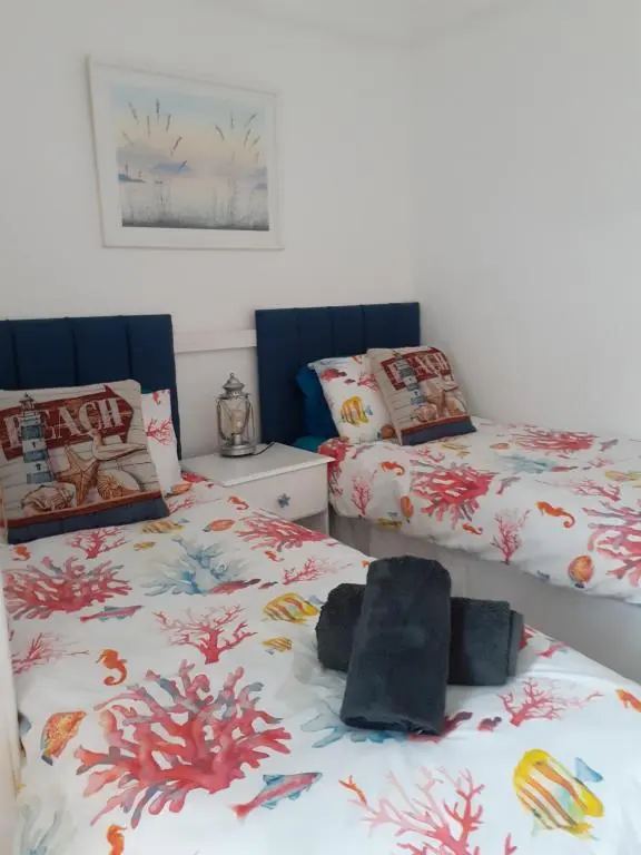 a bedroom with two beds and a stuffed animal at WELCOMEHOUSE close to east beach, shops, restaurants and RAF base in Lossiemouth