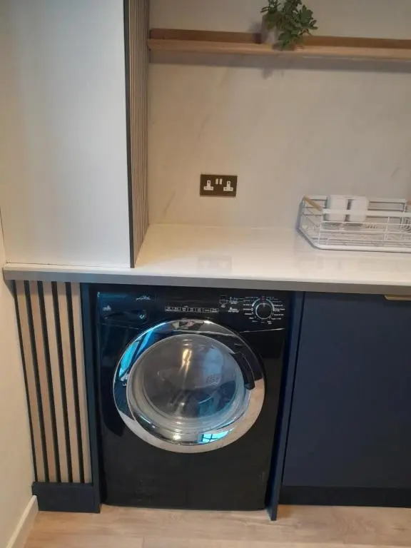 a washer and dryer under a counter in a kitchen at WELCOMEHOUSE close to east beach, shops, restaurants and RAF base in Lossiemouth