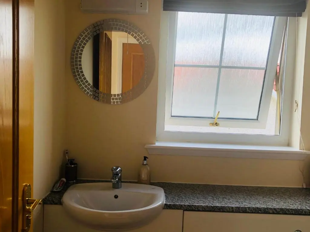 a bathroom with a sink and a window and a mirror at Taigh d'Luxe in Inverness