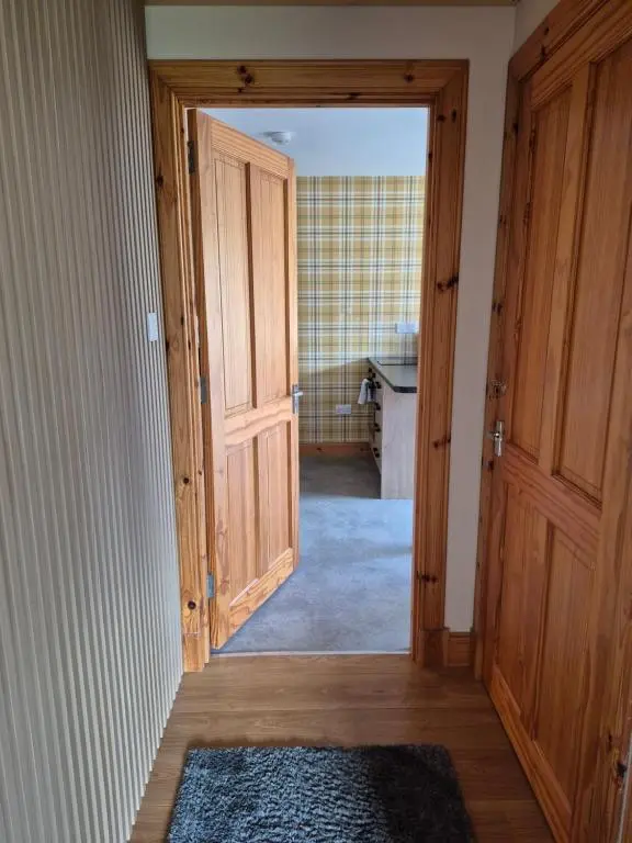 a hallway with an open door to a kitchen at The Studio in Drumnadrochit