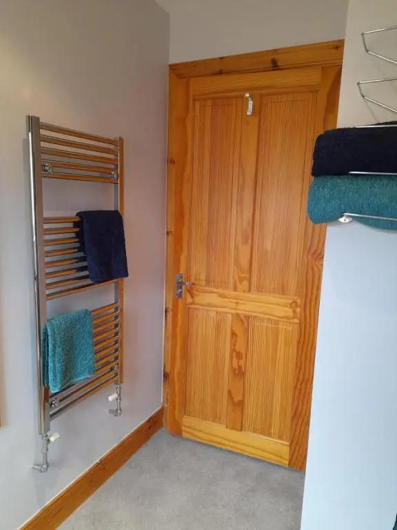 a room with a wooden door and some towels at The Studio in Drumnadrochit