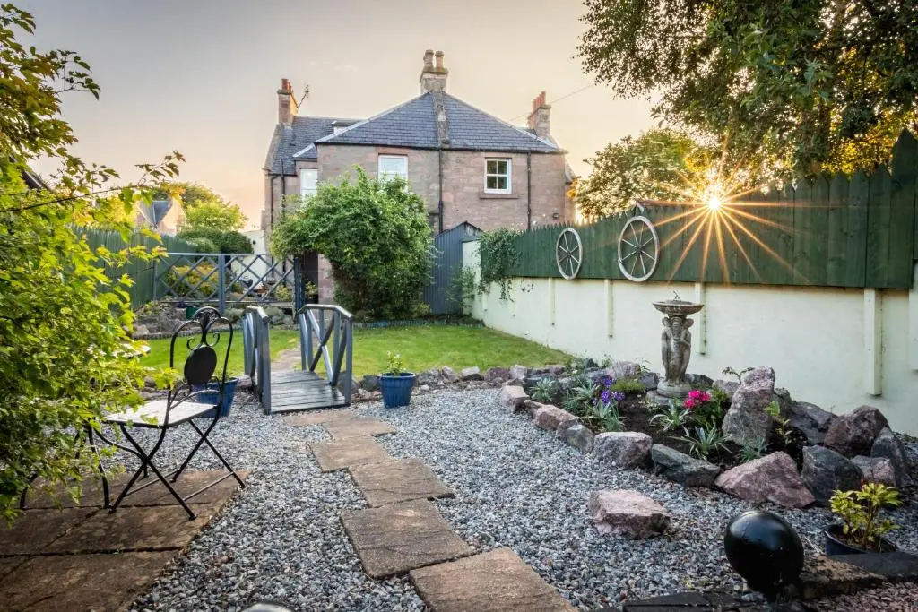 a backyard with a fence and a garden at West of the Ness in Inverness