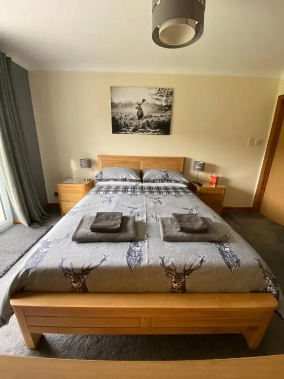 a bedroom with a bed with a wooden bed frame at The Willows in Dalchreichart