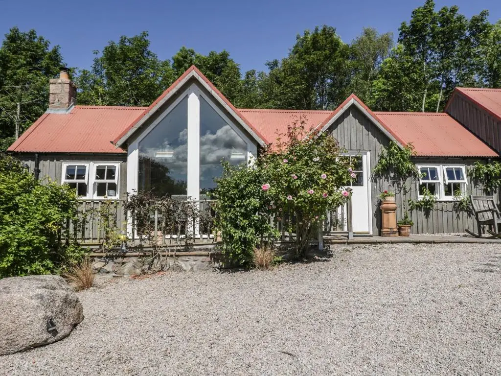 a house with a red roof and a gravel driveway at Drumhead Bothy in Banchory