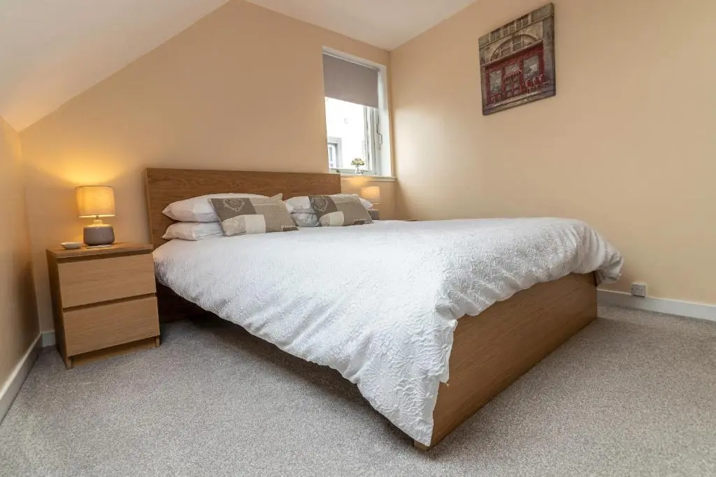 a bedroom with a large bed and a window at Fishertown House in Nairn