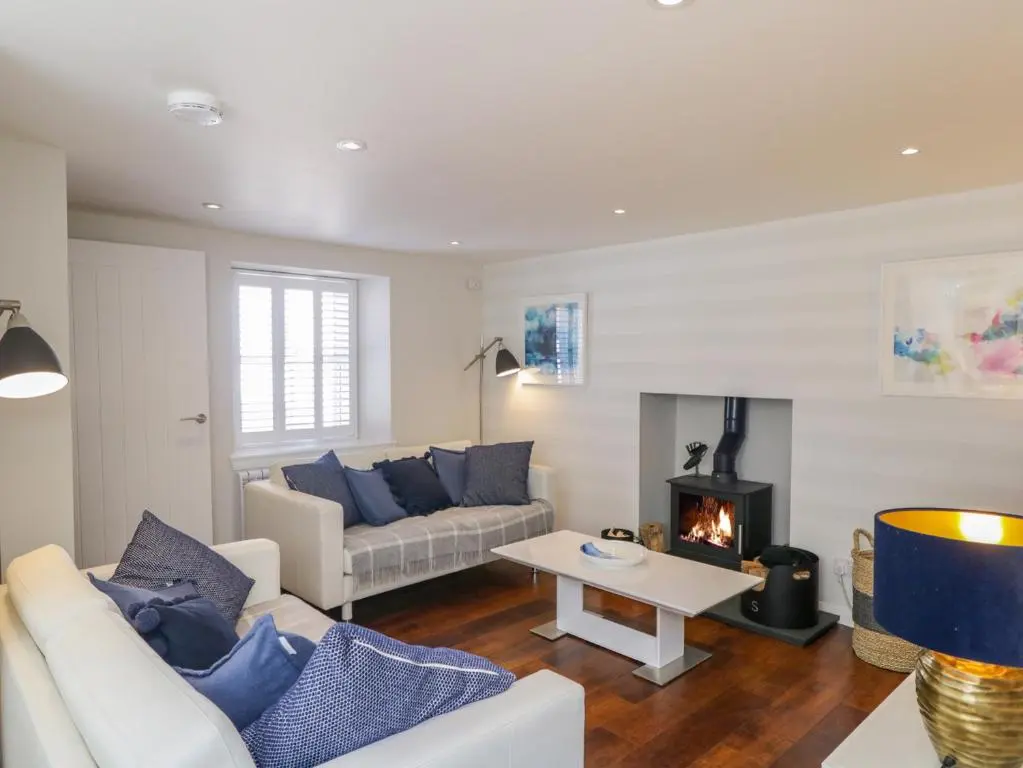 a living room with a couch and a fireplace at 36 Sandend Village in Banff