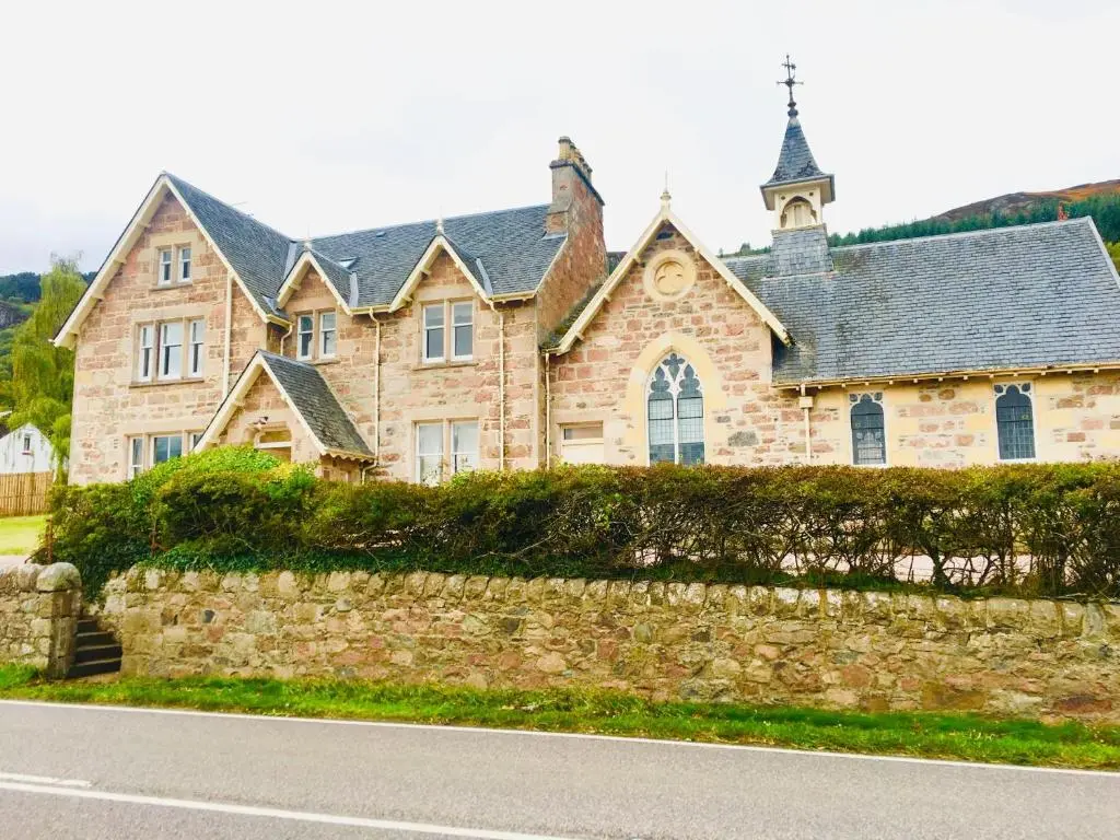 a large stone house with a stone wall at The Old Manse, Loch Ness (highland-escape) in Inverness