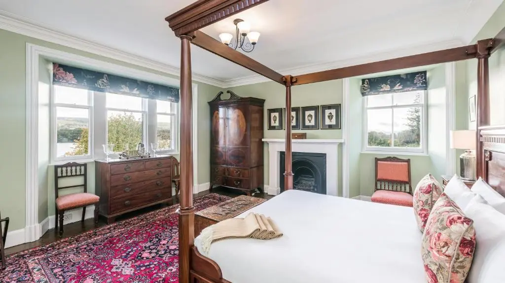 a bedroom with a large bed and a fireplace at The Old Manse, Loch Ness (highland-escape) in Inverness