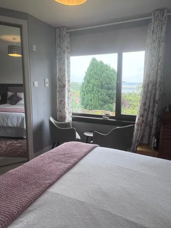 a bedroom with a bed and a large window at Black Isle View in Dingwall