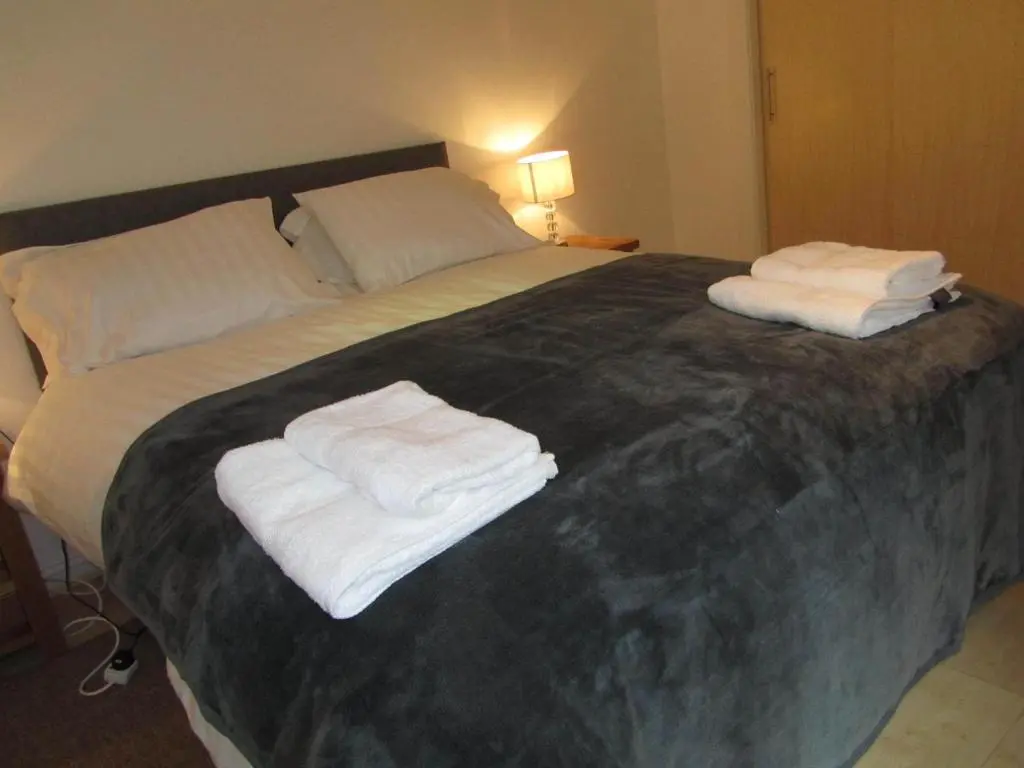 a bedroom with a bed with towels on it at River Walk Inverness in Inverness