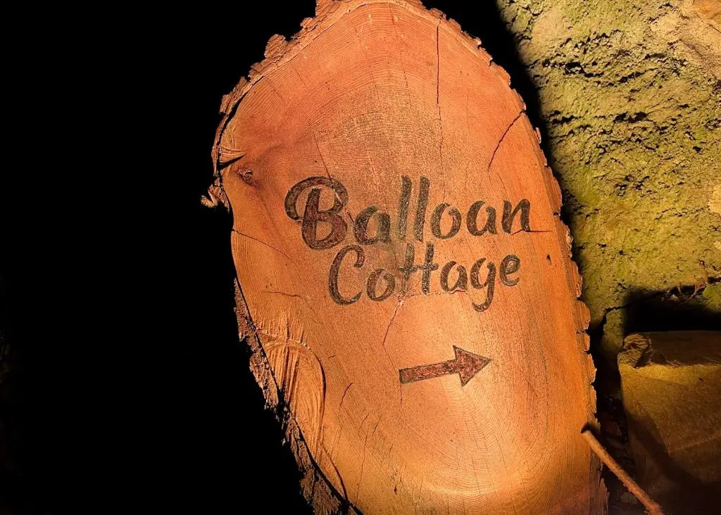 a log with the words bologna cottage written on it at Balloan Cottage Cowshed in Inverness