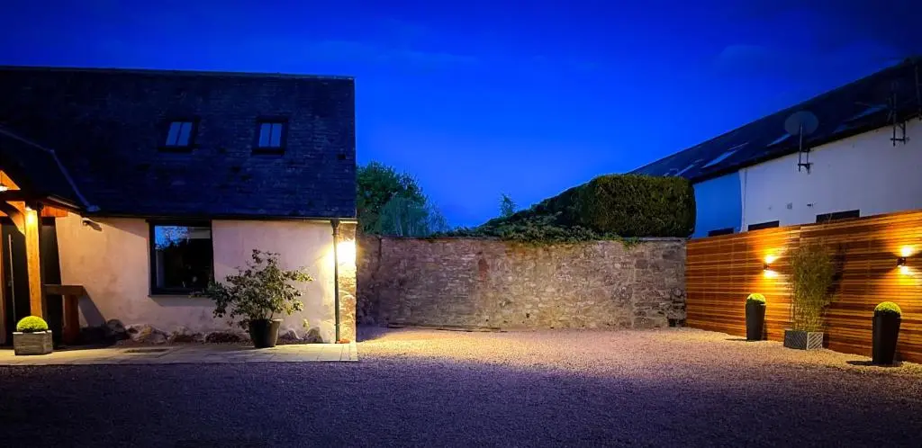 a building with lights on the side of it at night at Balloan Cottage Cowshed in Inverness