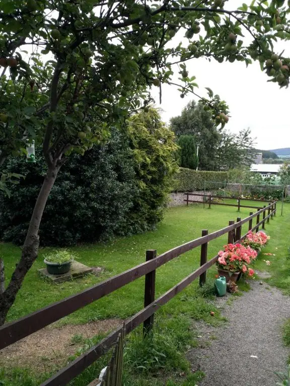 a wooden fence with flowers on a field at Mortlach Cottage in Dufftown