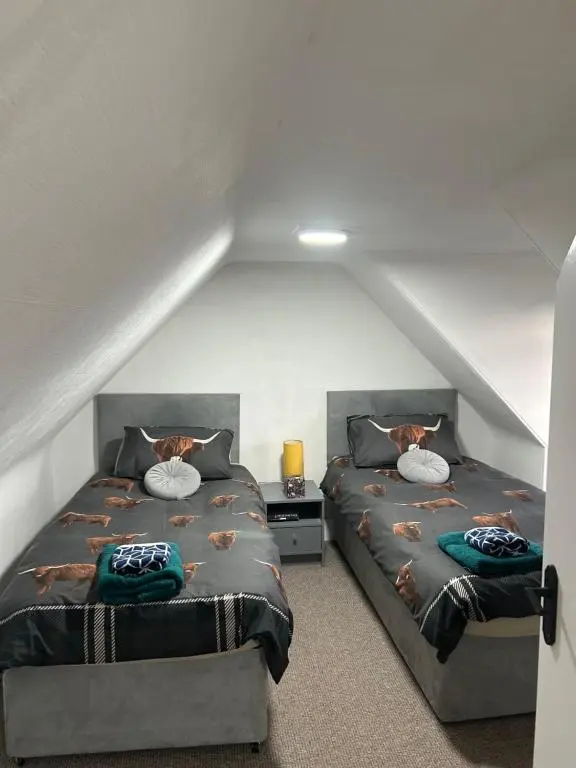 a attic bedroom with two beds in a attic at Mortlach Cottage in Dufftown