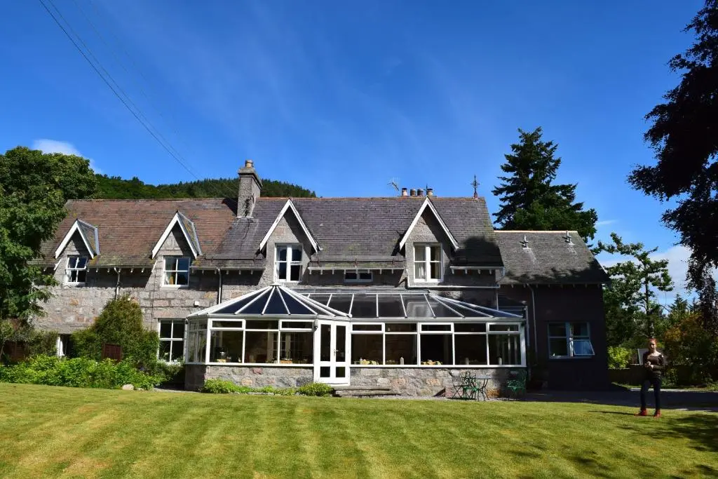 a man standing in front of a large house at The Cabin at No 45 in Ballater