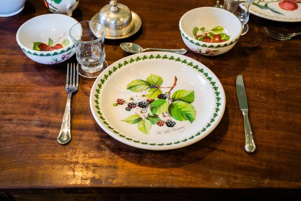 a wooden table with a plate of food on it at Scatwell House in Garve