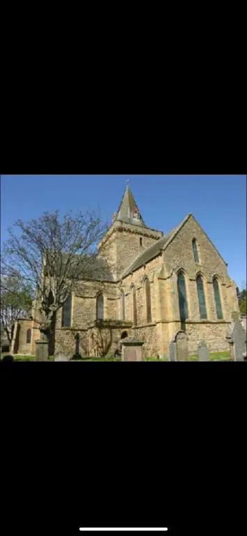 an old stone church with a tree in front of it at 23 C Allan Gardens in Dornoch