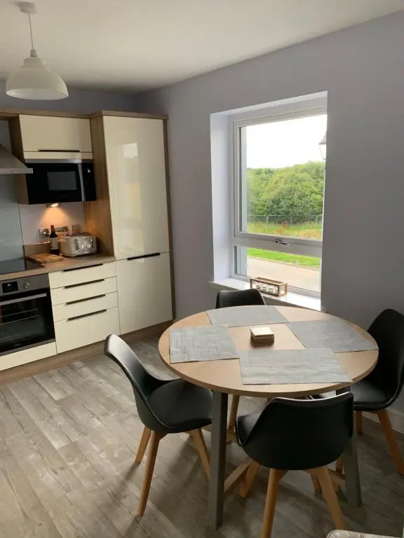 a kitchen and dining room with a table and chairs at 23 C Allan Gardens in Dornoch