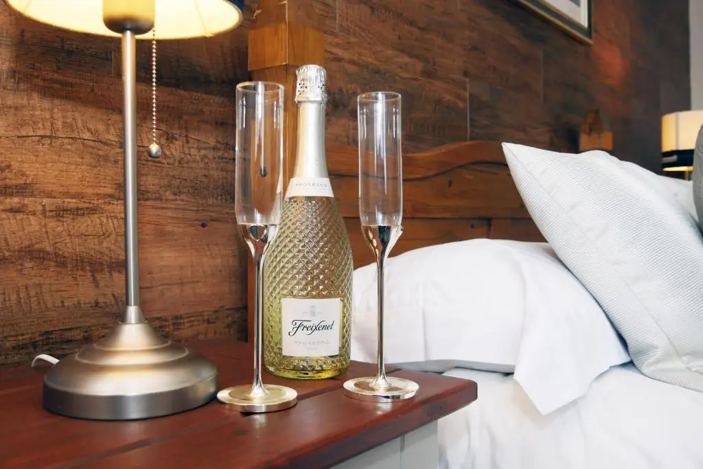 a bottle of champagne and two champagne glasses on a table at Ardentorrie Guest House in Inverness