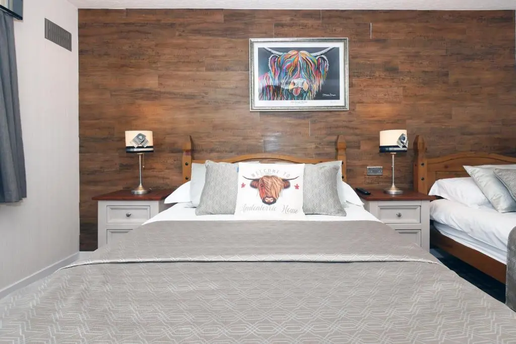 a bedroom with two beds and two lamps on tables at Ardentorrie Guest House in Inverness