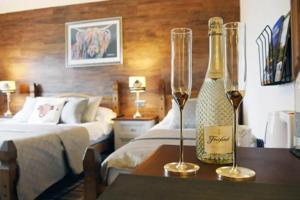 a hotel room with a bottle of wine on a table at Ardentorrie Guest House in Inverness