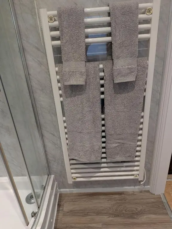 a towel rack in a shower with towels at The Highland Studio Muir of Ord in Muir of Ord