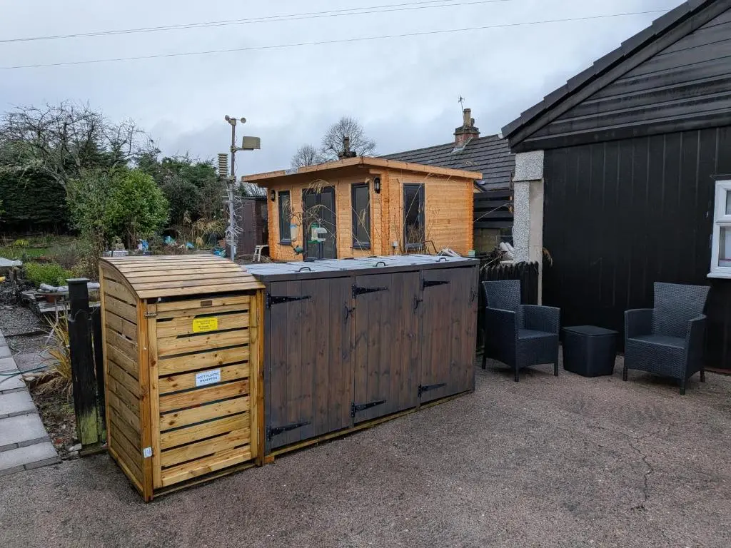 a backyard with a wooden bar with a house at The Highland Studio Muir of Ord in Muir of Ord