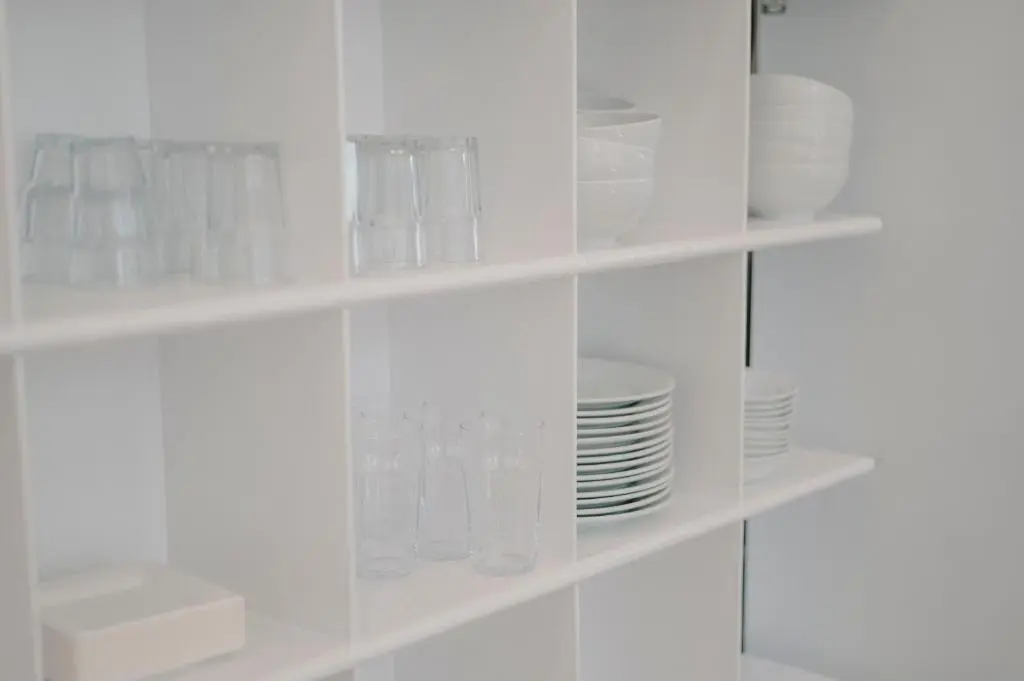 a white shelf filled with glasses and plates at Braemar Youth Hostel in Braemar