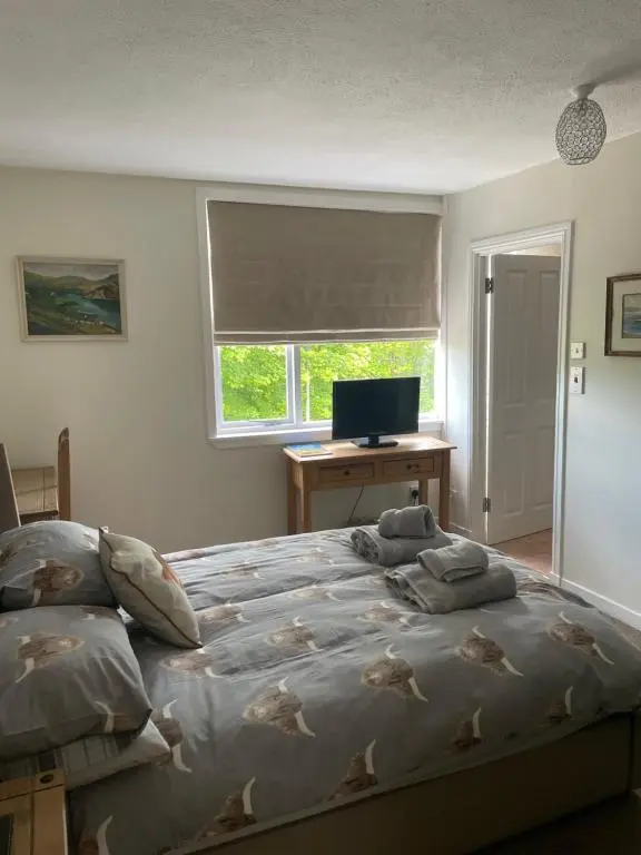 a bedroom with a bed and a desk with a computer at Charleston Apartment One Bedroom sleeping 2 in Inverness