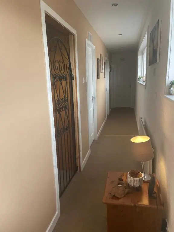 a hallway with a door and a table with a lamp at Charleston Apartment One Bedroom sleeping 2 in Inverness