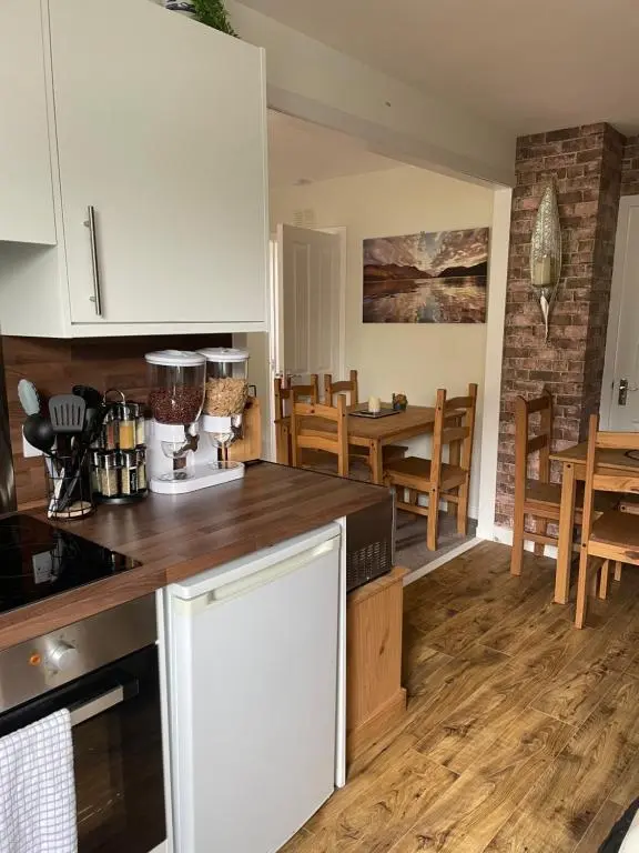 a kitchen with white cabinets and a table and chairs at Charleston Apartment One Bedroom sleeping 2 in Inverness