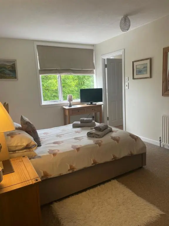 a bedroom with a bed with a desk and a window at Charleston Apartment One Bedroom sleeping 2 in Inverness