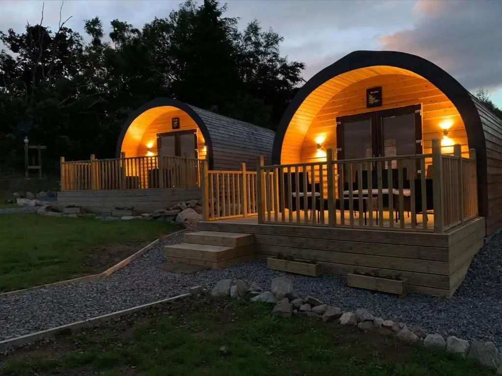 a small cabin with a porch and a deck at Daviot Luxury Pods in Inverness