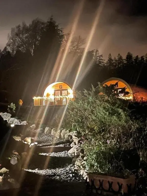 a garden with a building with beams of light at Daviot Luxury Pods in Inverness